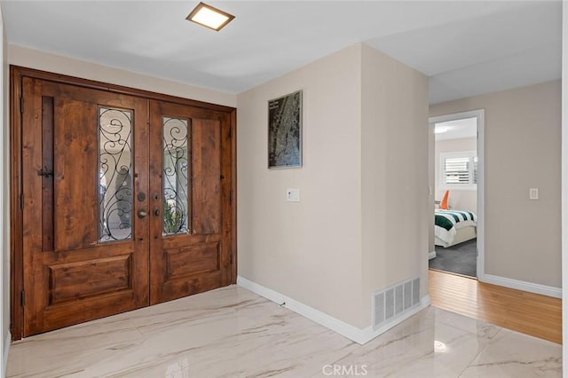 entryway with marble finish floor, visible vents, and baseboards