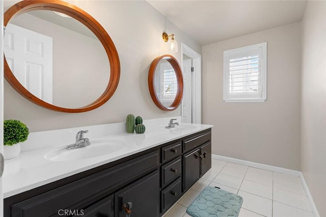 bathroom featuring double vanity, baseboards, a sink, and tile patterned floors