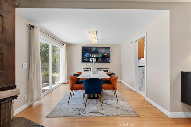 dining room featuring baseboards and light wood finished floors