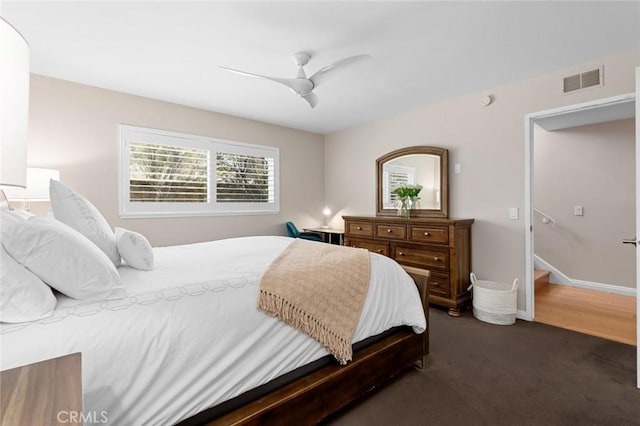 carpeted bedroom featuring a ceiling fan, visible vents, and baseboards