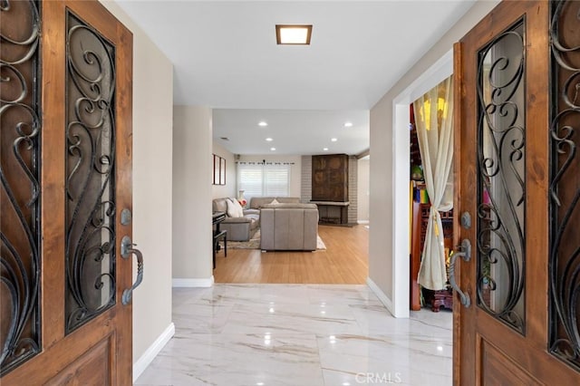 entrance foyer with recessed lighting, marble finish floor, and baseboards