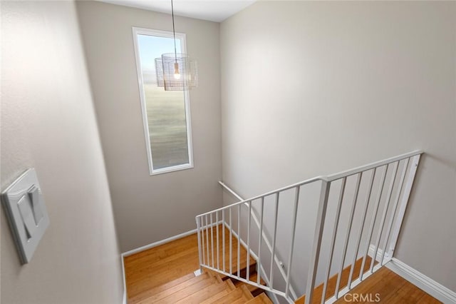 stairs with baseboards and wood finished floors