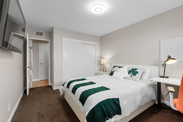 bedroom featuring carpet floors, a closet, visible vents, and baseboards