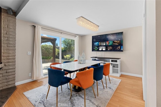 dining area featuring light wood-type flooring and baseboards