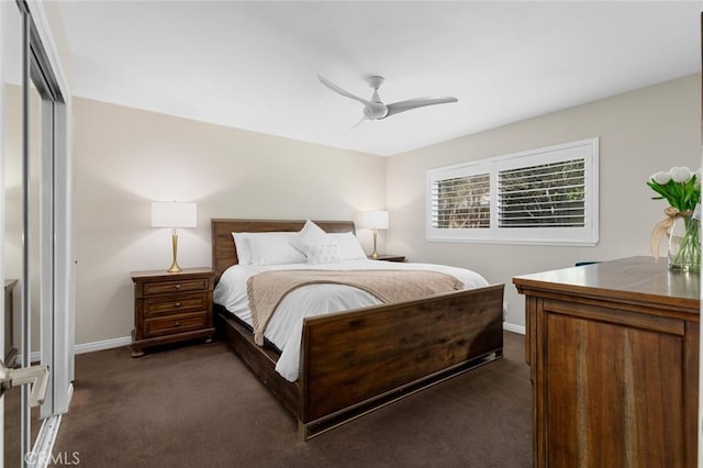 bedroom with baseboards, dark colored carpet, and a ceiling fan