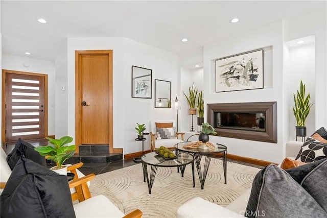 living room with a glass covered fireplace, baseboards, and recessed lighting