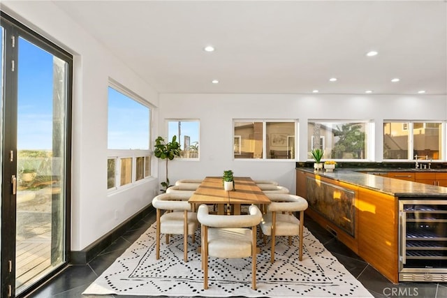 dining area with recessed lighting, beverage cooler, dark tile patterned flooring, and baseboards