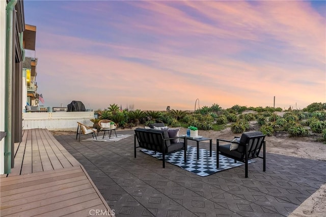 patio terrace at dusk with a deck and an outdoor living space