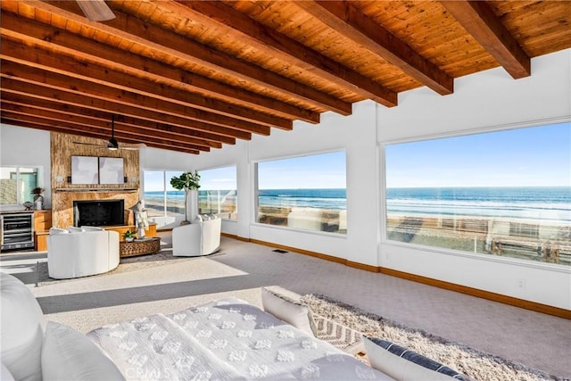 unfurnished sunroom featuring plenty of natural light, wood ceiling, wine cooler, and a large fireplace