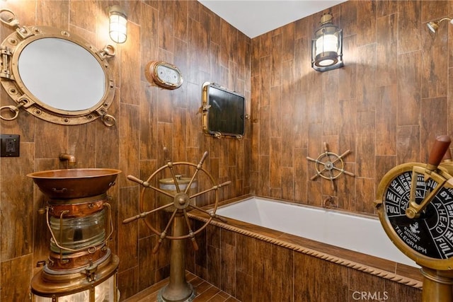 bathroom featuring tiled tub and tile walls