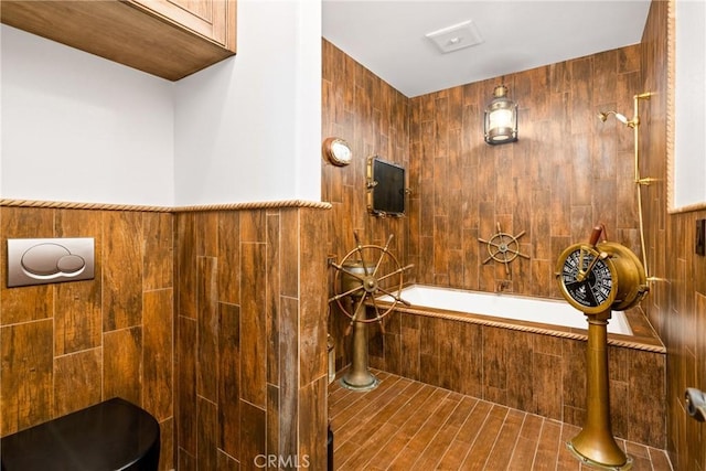 bathroom featuring a relaxing tiled tub, a tile shower, and tile walls