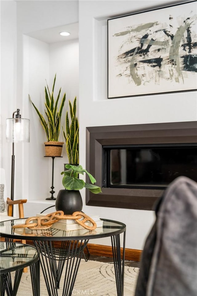 living area featuring a fireplace, baseboards, and wood finished floors