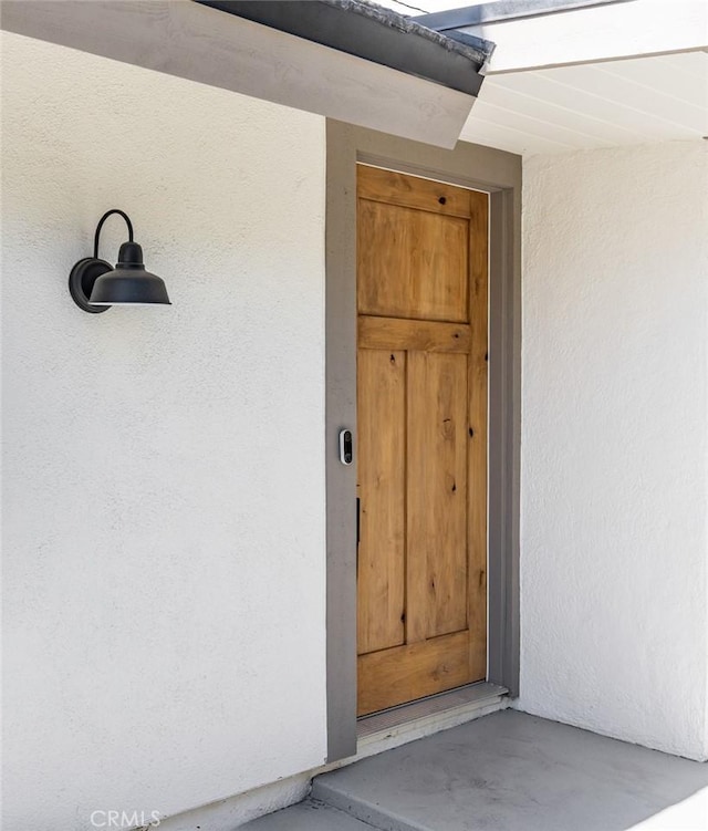 property entrance with stucco siding