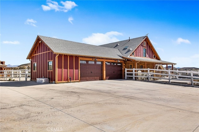 view of home's exterior featuring board and batten siding, a shingled roof, and driveway