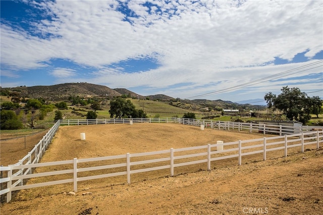 view of yard with an enclosed area, a mountain view, and a rural view