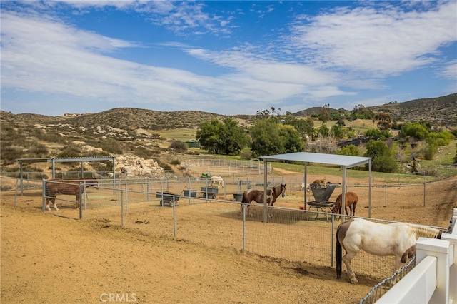 view of yard with a detached carport, a rural view, a mountain view, and an outdoor structure