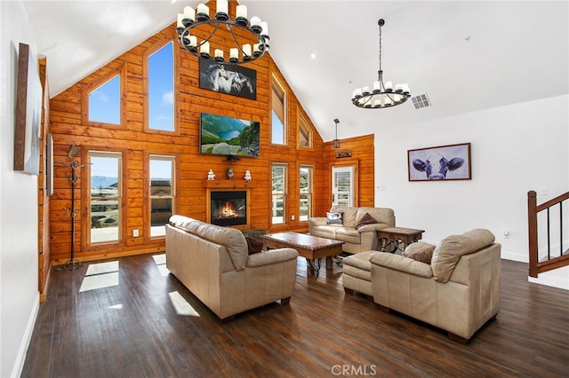 living area featuring wood walls, visible vents, a chandelier, and dark wood finished floors