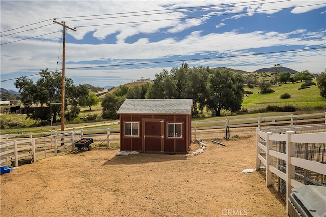 view of stable with a mountain view and a rural view