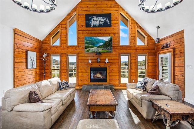 living area featuring dark wood-type flooring, a glass covered fireplace, a wealth of natural light, and an inviting chandelier