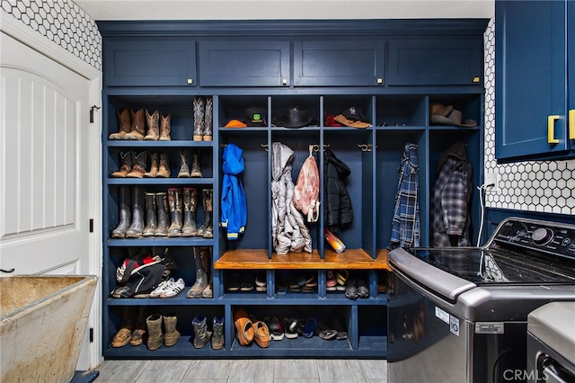 mudroom featuring a sink, wood finished floors, and washer and dryer