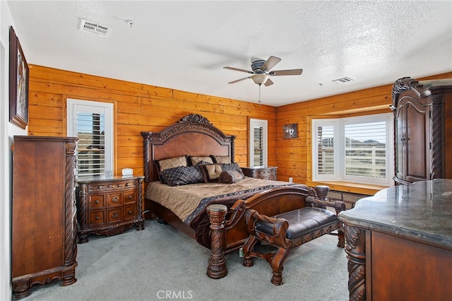 carpeted bedroom with a ceiling fan, visible vents, and a textured ceiling