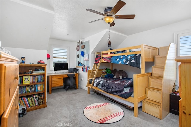 bedroom with light carpet, a ceiling fan, vaulted ceiling, and a textured ceiling