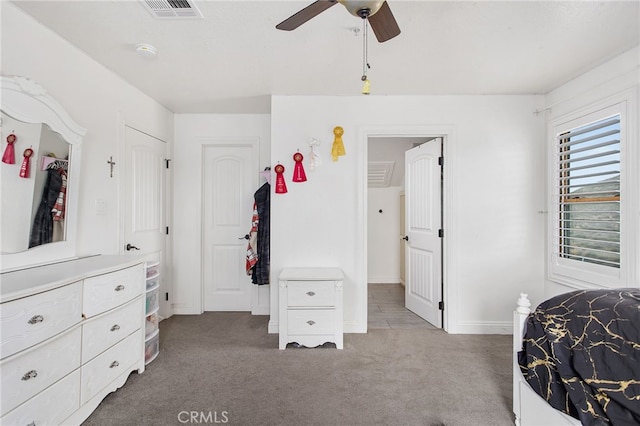 carpeted bedroom featuring a ceiling fan, visible vents, and baseboards