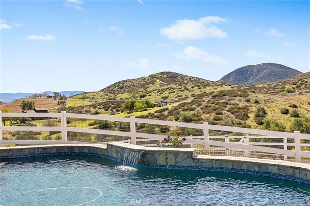 pool with fence and a mountain view