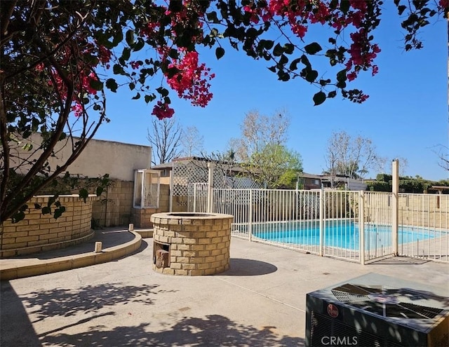 view of pool featuring cooling unit, fence, a fenced in pool, and a patio