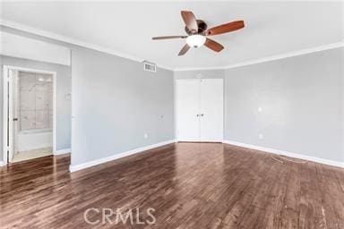 empty room with baseboards, ornamental molding, ceiling fan, and wood finished floors