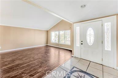 entrance foyer with lofted ceiling, wood finished floors, and baseboards