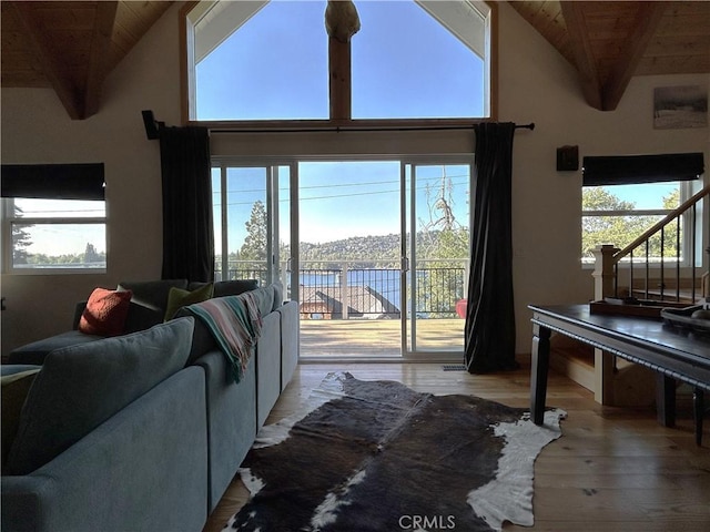 living room with light wood-type flooring, plenty of natural light, wood ceiling, and beamed ceiling