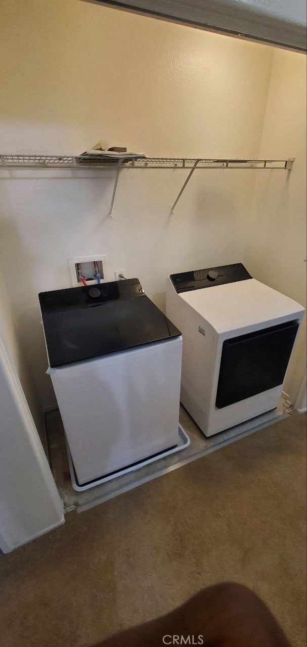 washroom featuring washer and dryer, carpet flooring, and laundry area