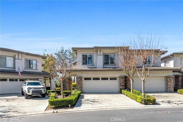 view of front of property with stone siding, stucco siding, concrete driveway, and a garage