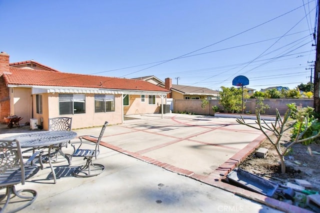 exterior space with a patio, stucco siding, central AC unit, fence, and a tiled roof