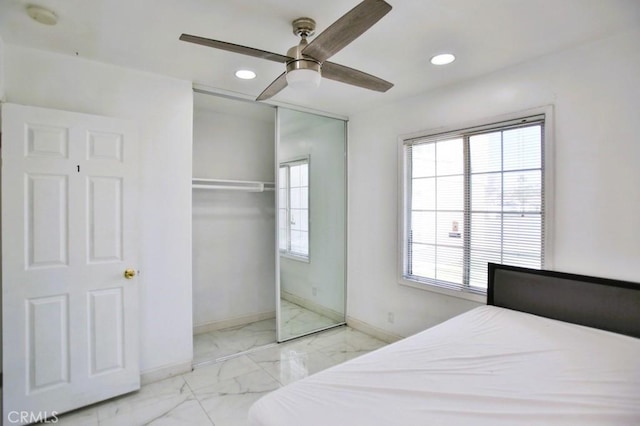 bedroom featuring marble finish floor, a closet, recessed lighting, and baseboards