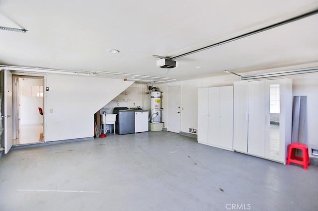 garage with a garage door opener, strapped water heater, and washer and clothes dryer