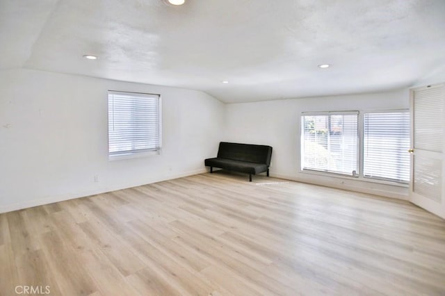 unfurnished room with lofted ceiling, light wood-style floors, baseboards, and recessed lighting