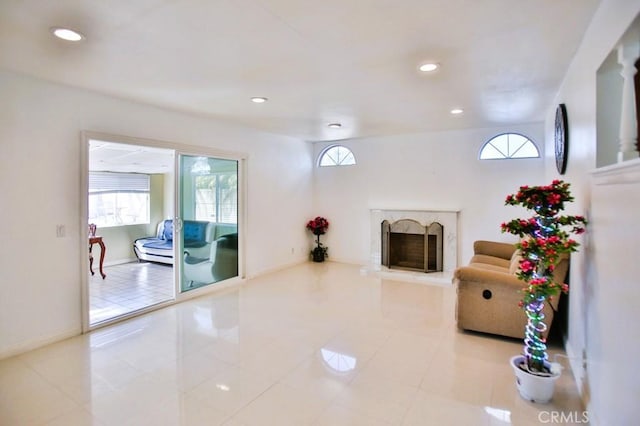 living area with recessed lighting, a fireplace, and baseboards