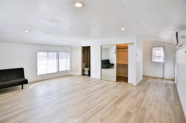 unfurnished bedroom featuring vaulted ceiling, light wood-type flooring, baseboards, and recessed lighting