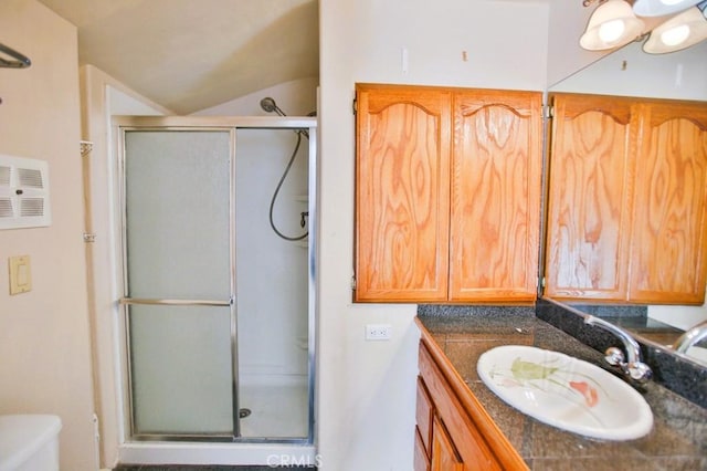 bathroom with lofted ceiling, toilet, a stall shower, and vanity