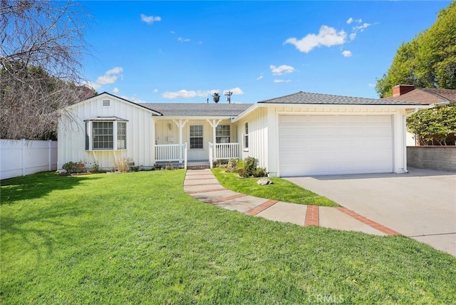 ranch-style house featuring a front yard, fence, driveway, covered porch, and a garage