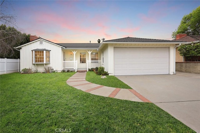 ranch-style home with driveway, fence, covered porch, an attached garage, and a front yard