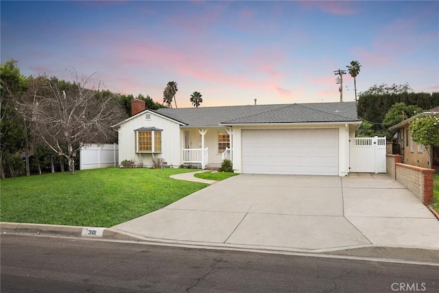 ranch-style home featuring concrete driveway, a yard, fence, and an attached garage