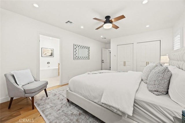 bedroom featuring baseboards, multiple closets, recessed lighting, light wood-style flooring, and ensuite bath