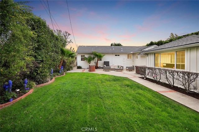 rear view of property featuring a yard, a patio, board and batten siding, and outdoor lounge area