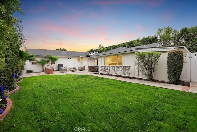 rear view of property with a patio area, a lawn, outdoor lounge area, and fence