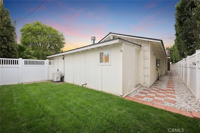 exterior space with a lawn, a fenced backyard, and ac unit