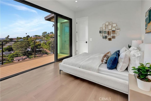 bedroom featuring access to outside, wood finished floors, and recessed lighting