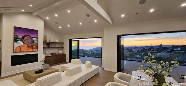 home theater with baseboards, a glass covered fireplace, wood finished floors, high vaulted ceiling, and beam ceiling